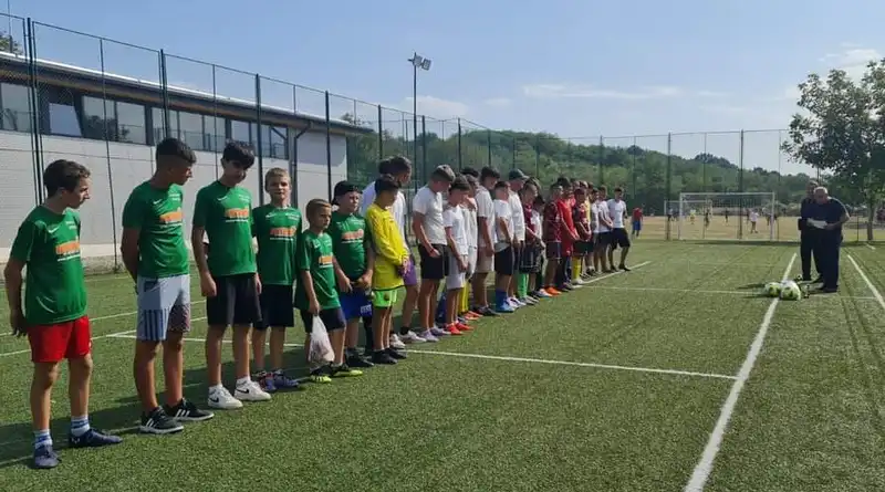 Un grup de tineri stând la rând pe un teren de fotbal.